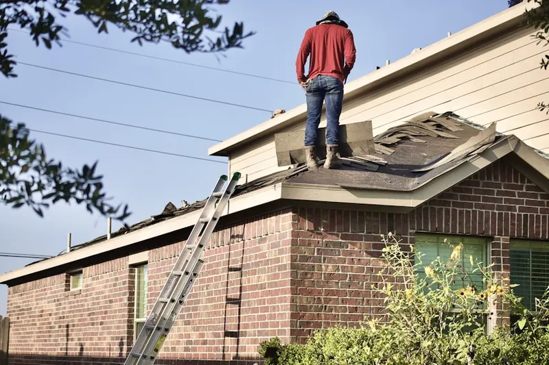Professional roofer working on a residential roof in Needham